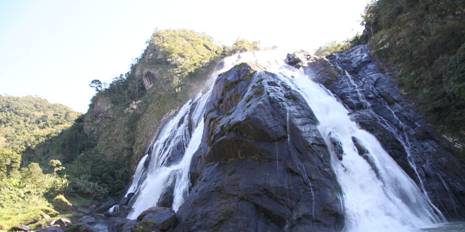 Cachoeira da Fumaça, queda d'água de grande altura entre rochas escuras e mata, entre Alegre e Ibitirama